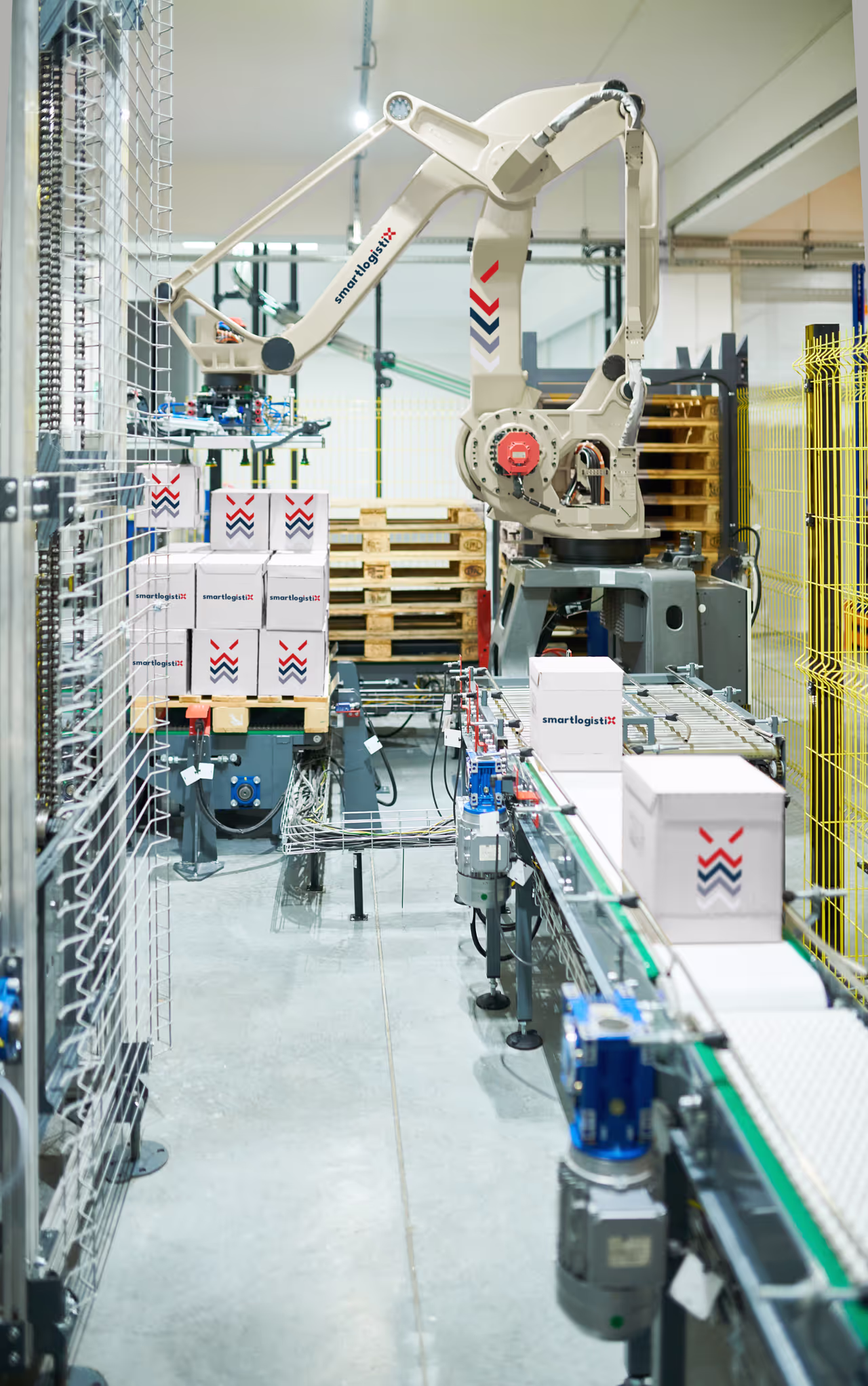 SmartLogistiX robotic arm palletizing boxes on an automated conveyor line