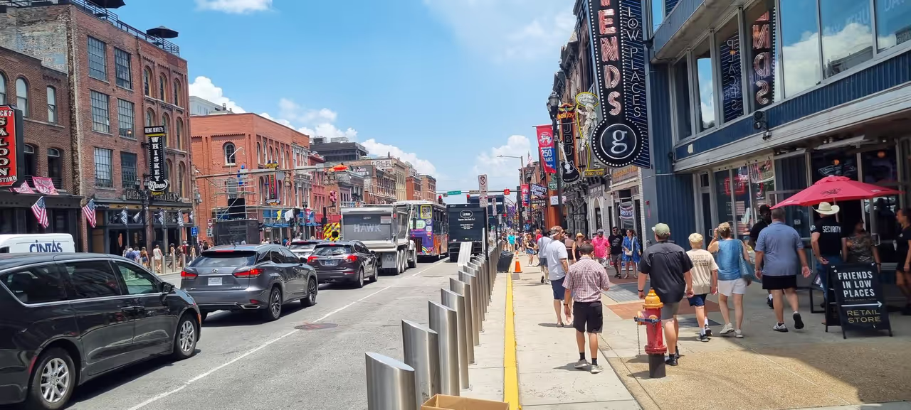 Lower Broadway in Nashville on a sunny afternoon, lined with honky-tonk bars, neon signs and visitors — the backdrop to the World of Wipes 2026 conference